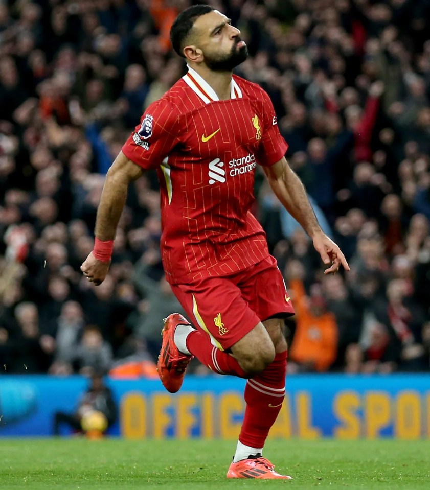 a soccer player wearing a red jersey that says ' standard chartered ' on it