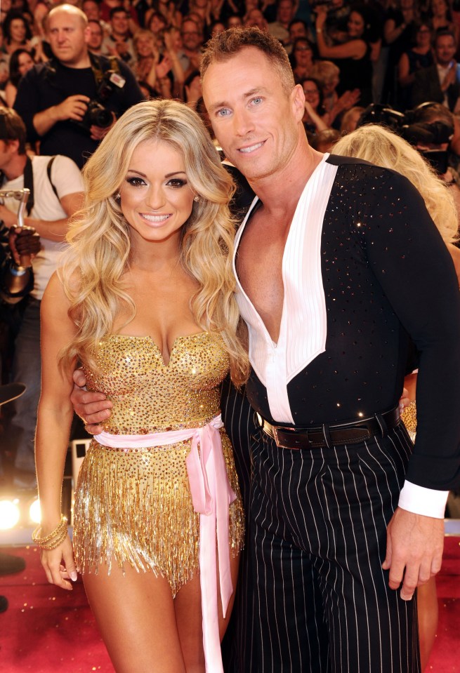 a man and a woman are posing for a picture on a red carpet