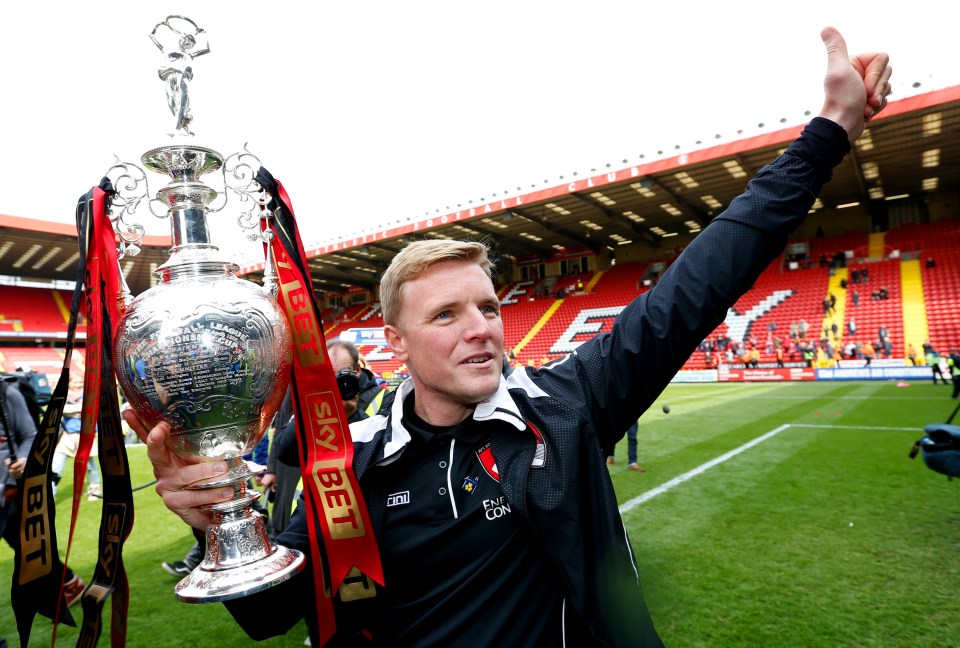 a man holds up a trophy that says sky bet on it