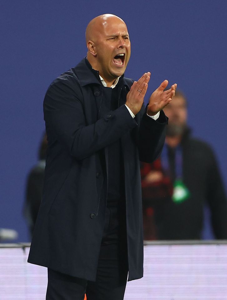 a bald man in a trench coat is clapping his hands