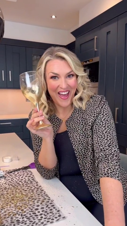 a woman in a leopard print jacket is holding a glass of wine