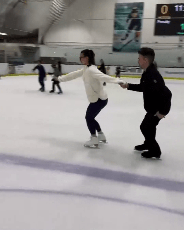 a man and a woman are holding hands while ice skating