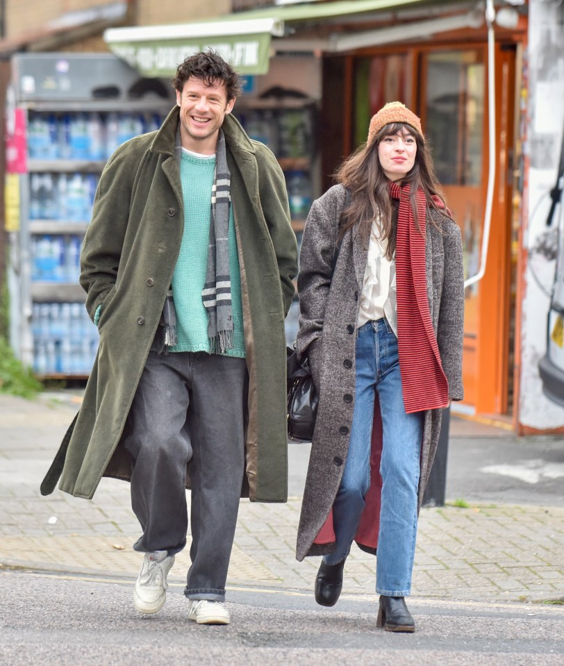 a man and a woman are walking down a street in front of a store that sells bottled water