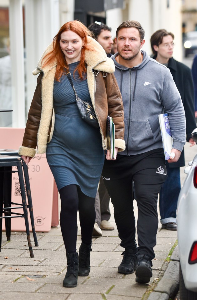 a woman in a blue dress is walking with a man in a nike hoodie