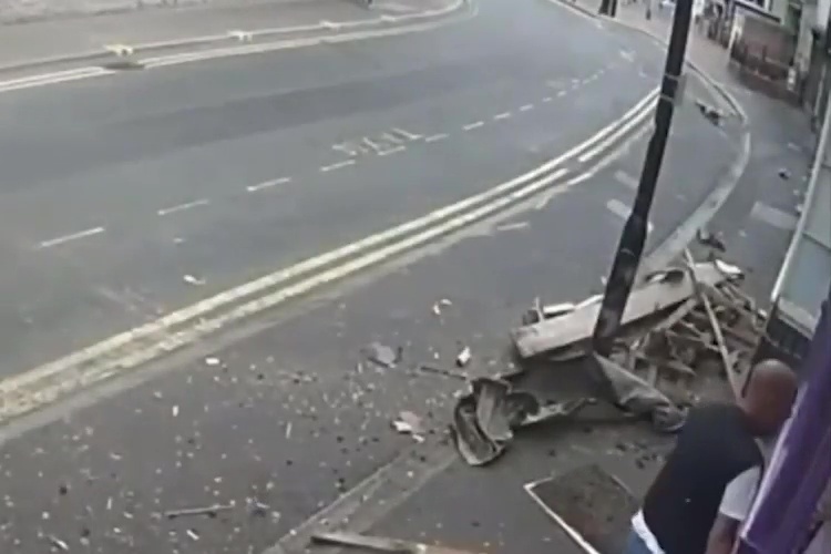 a car has crashed into a pole on the side of the road .