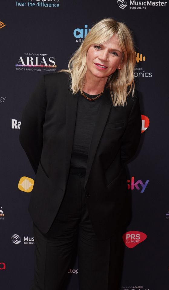 a woman stands on a red carpet that says arias