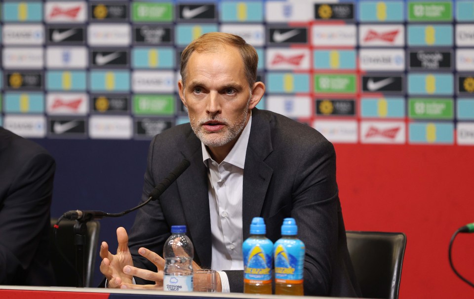 a man speaking into a microphone with two bottles of aquafina in front of him