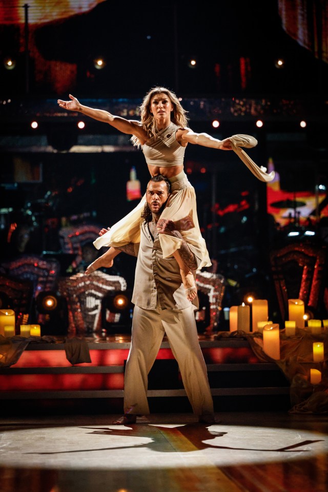 a man is carrying a woman in the air on his shoulders