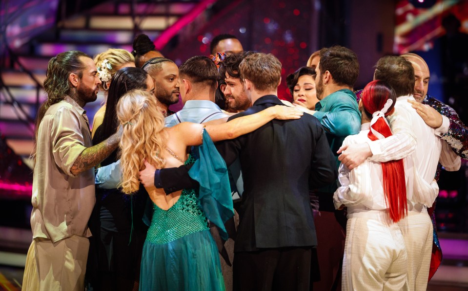 a group of people hugging each other on a stage