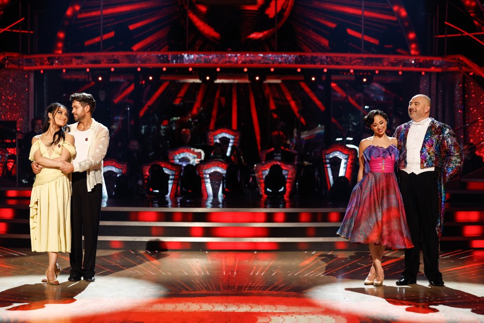 a group of people standing on a stage with a red background