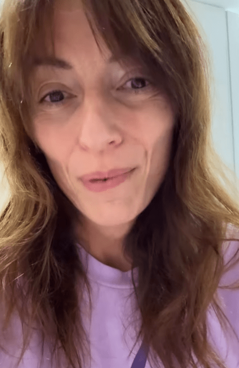 a woman with long brown hair is wearing a purple shirt