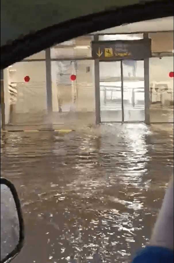a flooded building with a sign that says arrivals