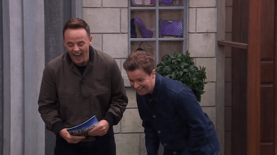 two men are laughing and one is holding a magazine that says ' i love you ' on it