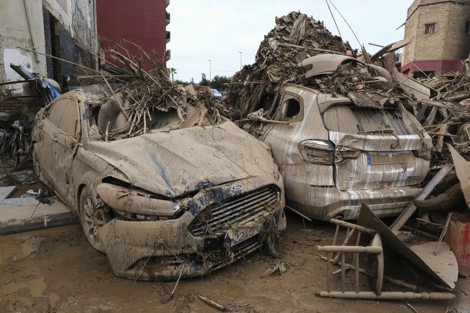 a ford car is covered in mud next to another car