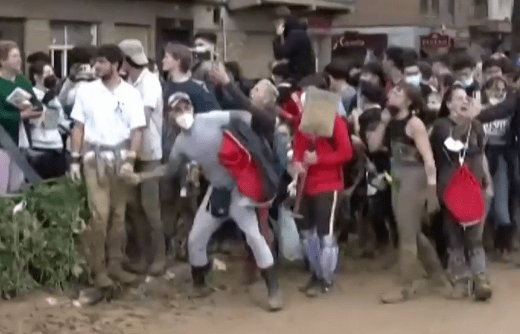 a large group of people are standing in the mud .