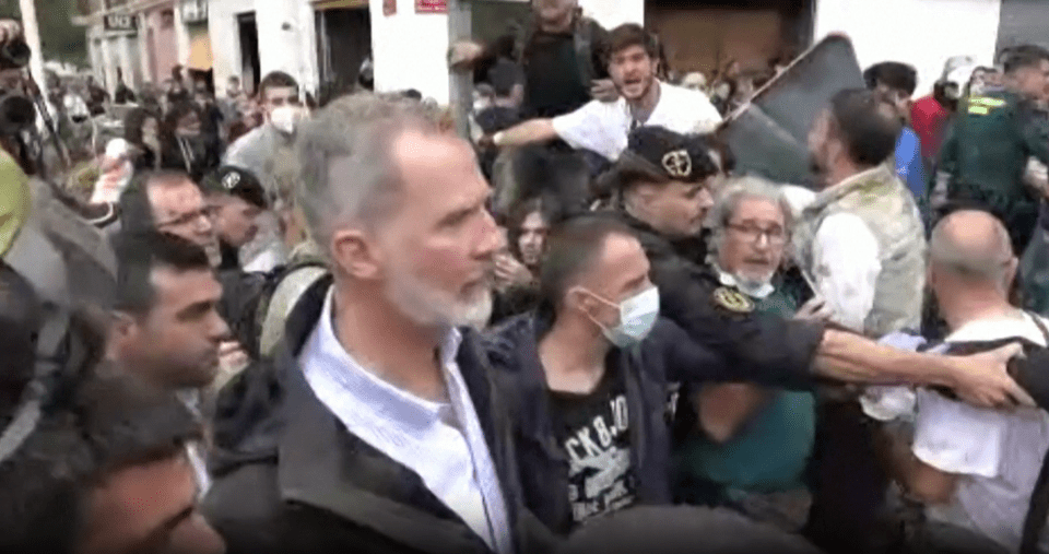 a man with a beard is standing in a crowd of people .
