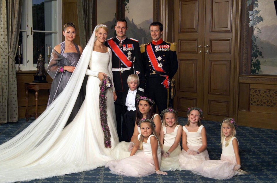 Wedding portrait of a bride and groom with their families and flower girls.