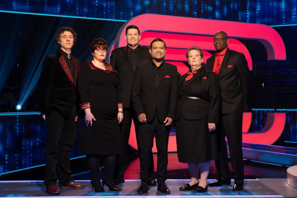 a group of people standing in front of a red circle