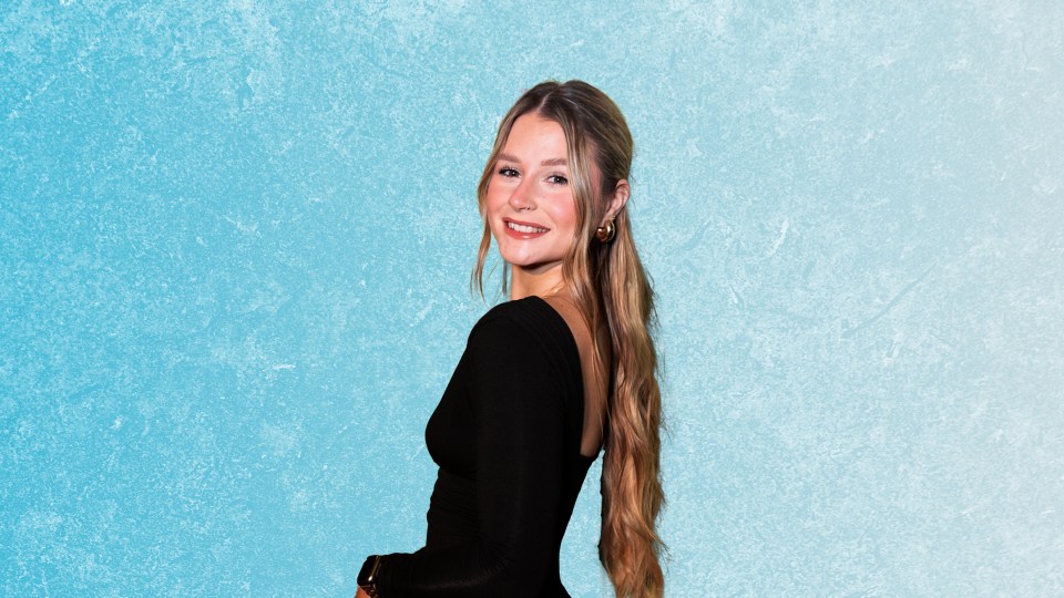 a woman in a black dress stands in front of a blue background