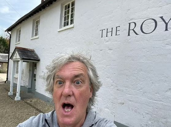 a man is taking a selfie in front of a white building .