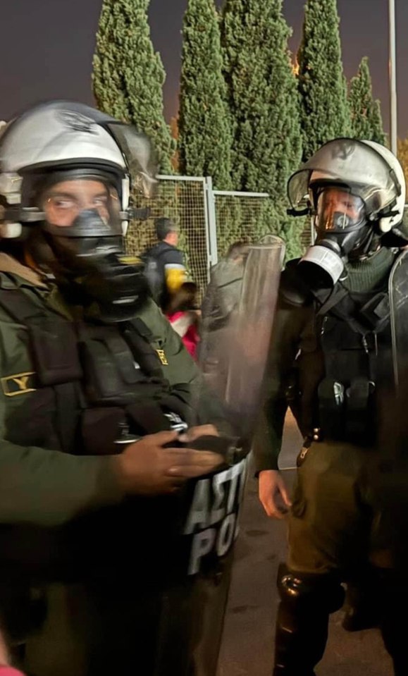 two police officers wearing gas masks are standing next to each other