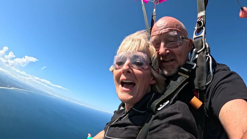 a man and a woman wearing goggles are flying through the air