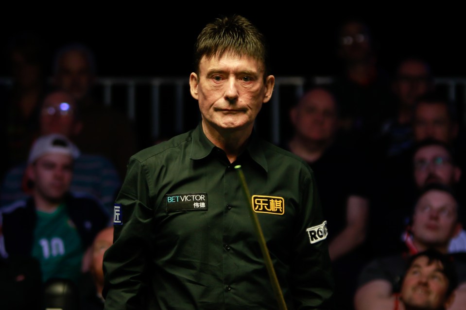 a man wearing a bet victor shirt stands in front of a crowd