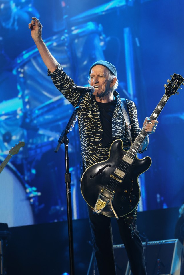 a man playing a guitar and singing into a microphone