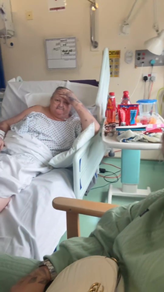 an elderly woman in a hospital bed with a sign on the wall that says ' nurse ' on it