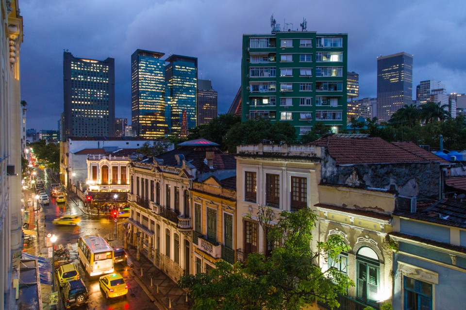 an aerial view of a city at night with a green building in the foreground