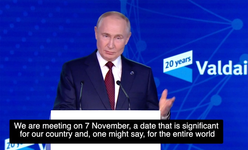 a man stands at a podium with a 20 years valdai logo behind him