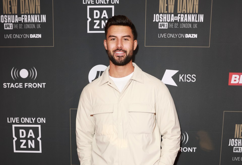 a man stands in front of a dazn advertisement