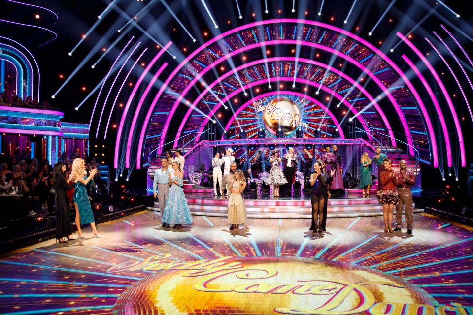 a group of people standing on a stage with the words strictly come dancing on the floor