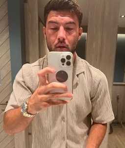 a man is taking a selfie with his cell phone in a bathroom .