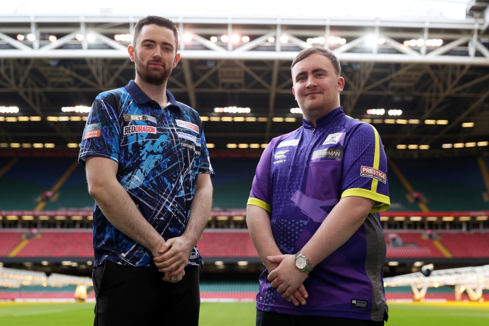 two men standing in front of a stadium with one wearing a purple shirt
