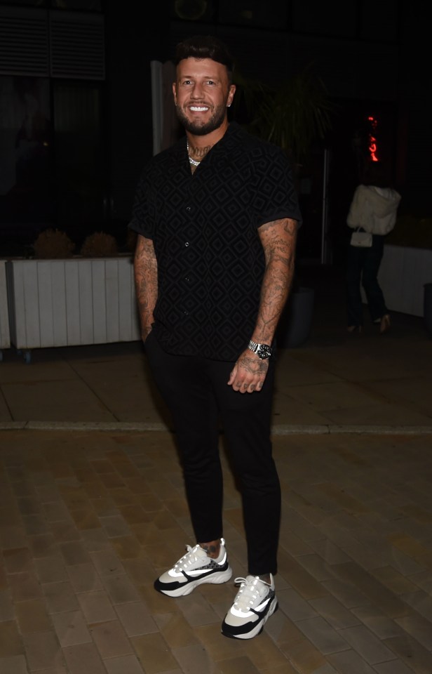 a man wearing a black shirt and white nike shoes