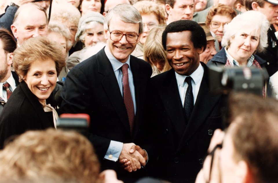 a man and woman shaking hands in front of a crowd