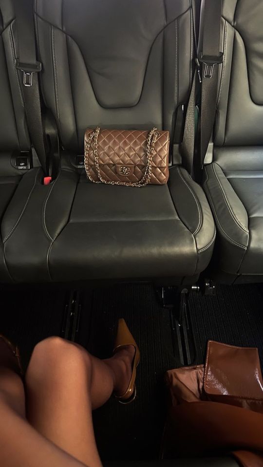 a chanel purse sits on the back seat of a car