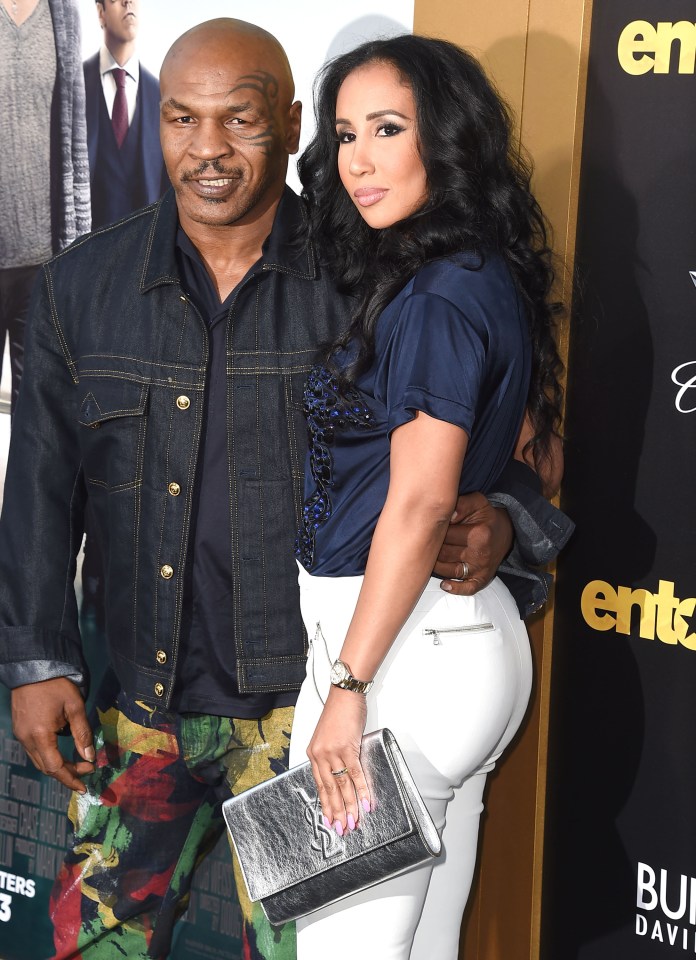mike tyson and his wife pose on the red carpet