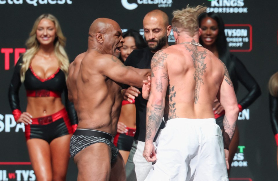 two men are standing in front of a sign that says tyson sportsbook