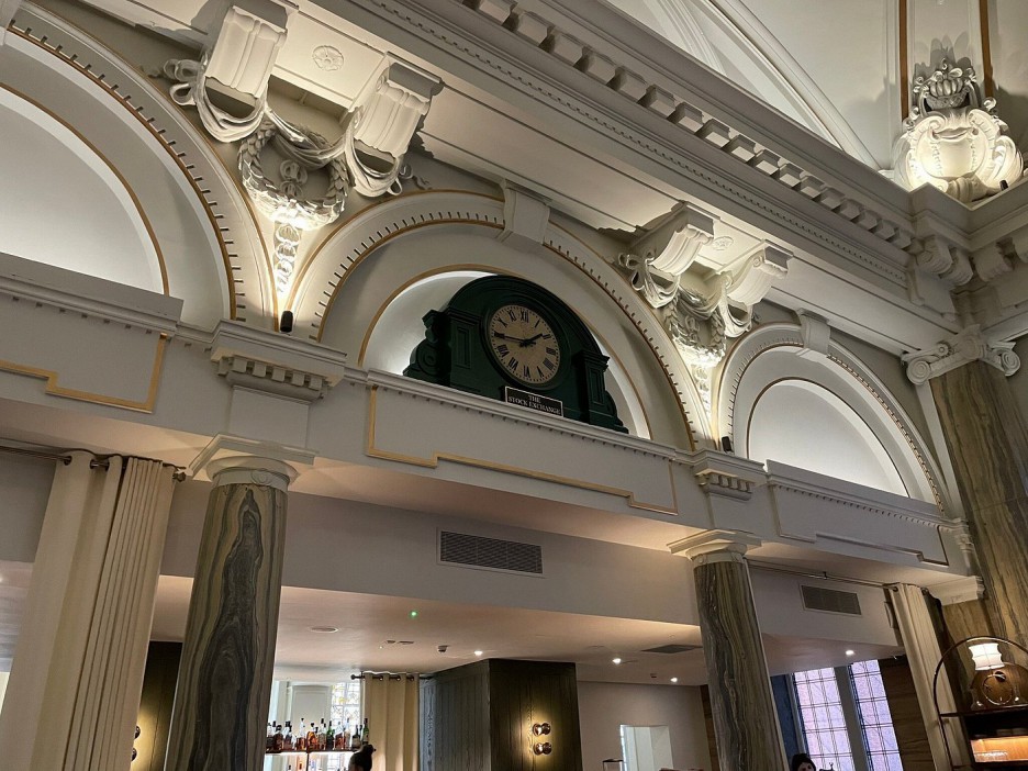 a clock hanging from the ceiling of a building shows the time as 4:20
