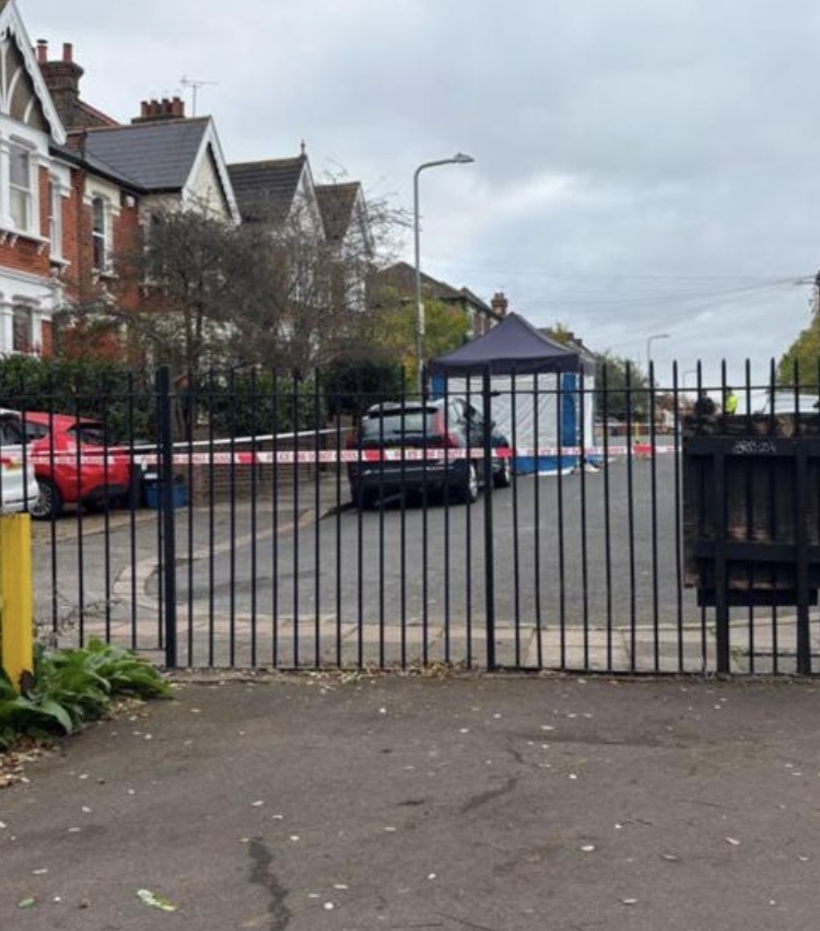 a car is parked in a parking lot behind a fence that says ' ambulance ' on it