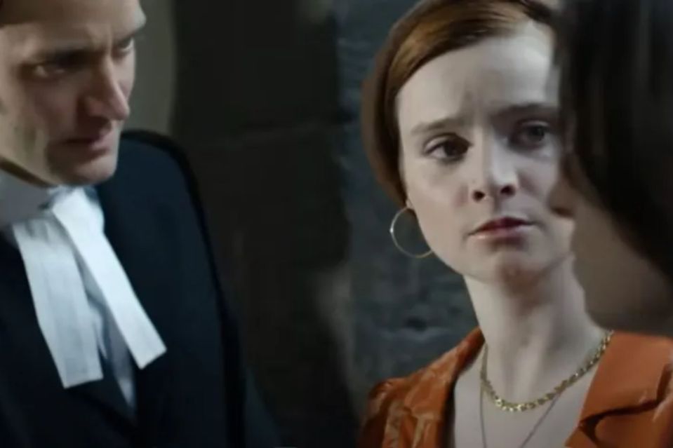 a man in a suit and tie is standing next to two women .