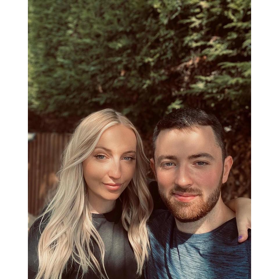 a man and a woman posing for a picture with trees in the background