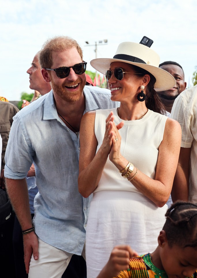 a man wearing sunglasses and a hat stands next to a woman wearing a white dress