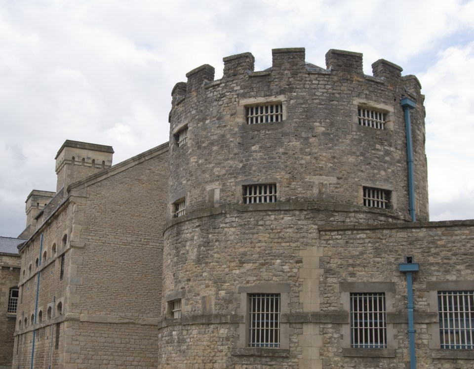 a stone building with a tower and bars on the windows
