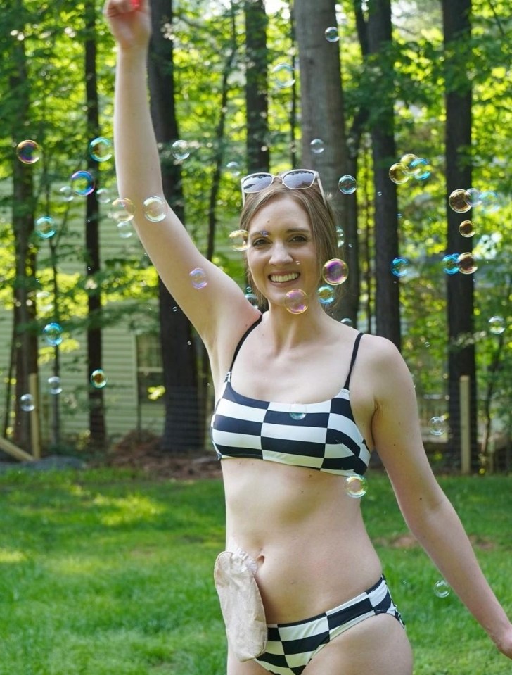 a woman in a bikini is playing with soap bubbles