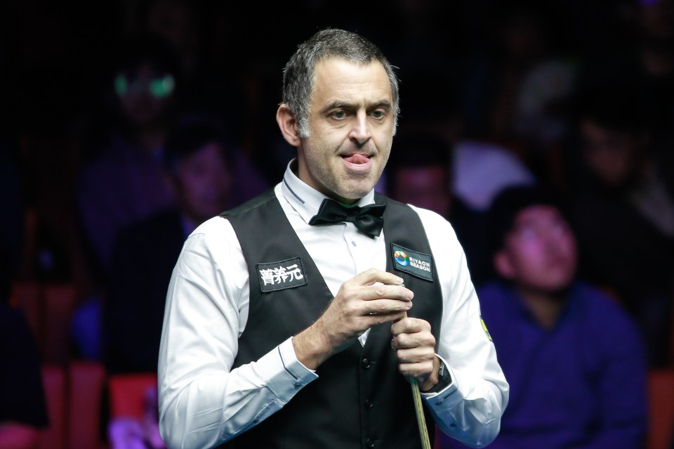 a man in a black shirt is playing snooker