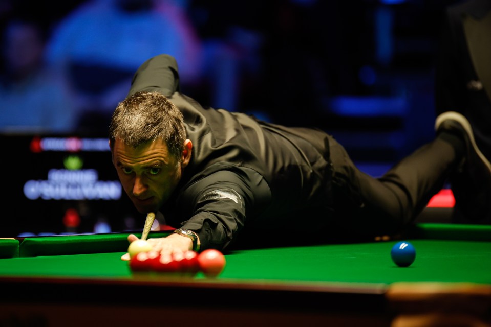 a man in a black shirt is playing snooker