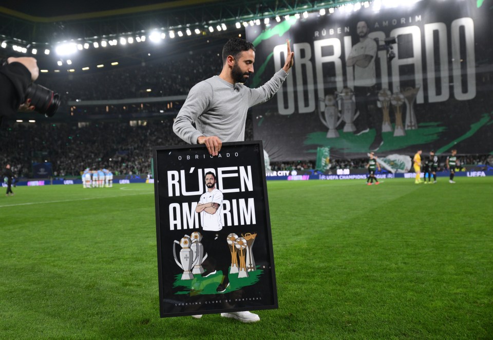 a man holds up a framed picture of ruben amirim